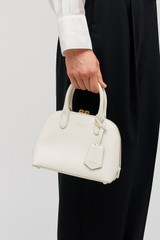 Profile view of model wearing the Oroton Muse Micro Griptop in Paper White and Embossed leather with smooth leather trims for Women