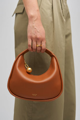 Profile view of model wearing the Oroton Clara Smooth Mini Bag in Amber and Smooth Leather Exterior for Women