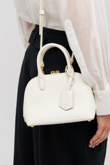 Profile view of model wearing the Oroton Muse Micro Griptop in Paper White and Embossed leather with smooth leather trims for Women