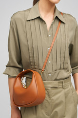Profile view of model wearing the Oroton Clara Smooth Mini Bag in Amber and Smooth Leather Exterior for Women