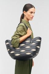Profile view of model wearing the Oroton Leigh Ric Rac Medium Tote in Black and Smooth leather for Women