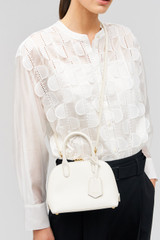 Profile view of model wearing the Oroton Muse Micro Griptop in Paper White and Embossed leather with smooth leather trims for Women