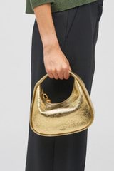 Profile view of model wearing the Oroton Clara Mini Bag in Gold and Metallic crinkle leather for Women