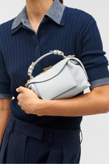 Profile view of model wearing the Oroton Mica Mini Bowler in Mist and Pebble leather for Women