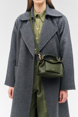 Profile view of model wearing the Oroton Mica Mini Bowler in Dark Khaki and Pebble leather for Women