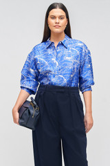 Profile view of model wearing the Oroton Long Sleeve Map Print Camp Shirt in Indigo and 100% silk for Women