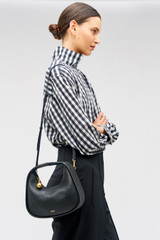Profile view of model wearing the Oroton Clara Mini Bag in Black and Pebble leather for Women