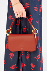 Profile view of model wearing the Oroton Liv Small Day Bag in Dark Poppy and Pebble leather for Women