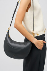 Profile view of model wearing the Oroton Florence Medium Hobo in Black and Smooth leather for Women