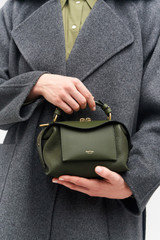 Profile view of model wearing the Oroton Mica Mini Bowler in Dark Khaki and Pebble leather for Women