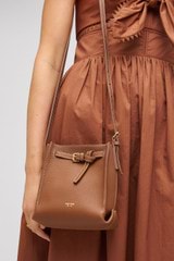 Profile view of model wearing the Oroton Margot Tiny Bucket Bag in Whiskey and Smooth leather for Women
