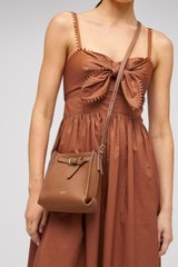Profile view of model wearing the Oroton Margot Tiny Bucket Bag in Whiskey and Smooth leather for Women