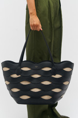 Profile view of model wearing the Oroton Leigh Ric Rac Medium Tote in Black and Smooth leather for Women
