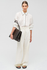 Profile view of model wearing the Oroton Audrey Texture Three Pocket Day Bag in Mahogany and Textured leather for Women