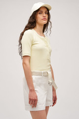 Profile view of model wearing the  Margot Rib Henley in Lemon and 92% Cotton / 8% Spandex for Men