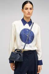 Profile view of model wearing the Oroton Mica Mini Bowler in North Sea and Pebble leather for Women
