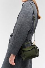 Profile view of model wearing the Oroton Mica Mini Bowler in Dark Khaki and Pebble leather for Women