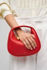 Profile view of model wearing the Oroton Clara Smooth Mini Bag in Dark Poppy and Smooth Leather Exterior for Women